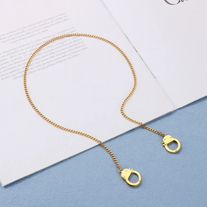 Golden titanium steel jewelry set featuring a handcuff pendant on a fine link chain necklace