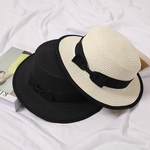 Detail showing woven texture of white and black straw boater hats with ribbon bows