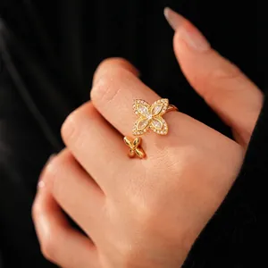 Bague ajustable en or avec motif trèfle en zircone sur la main d'un modèle