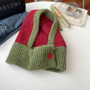 Close-up of red and green color-block knitted balaclava hood with a decorative button