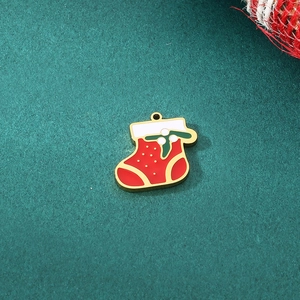 Detail of red and green enamel Christmas stocking pendant with gold metal border