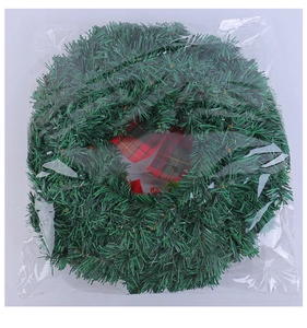 Close-up of green pine needle Christmas wreath with red plaid bow in clear packaging