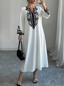 Elegante abito lungo bianco con scollo a V, ricami neri e maniche lunghe da donna