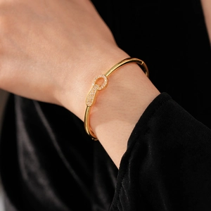 Detail of a gold plated zircon bracelet on wrist with elegant buckle and pavé setting
