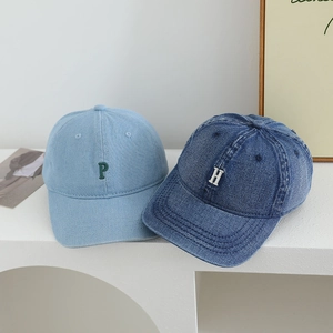 Detailed view of light and dark blue denim baseball caps with 3D letter embroidery