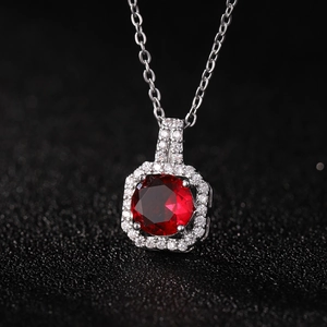 Silver necklace with red zircon perfume bottle pendant and crystal halo on black fabric