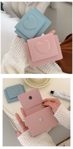 Detail showing macaron blue and pink heart-embossed PU leather mini wallets with interior slots