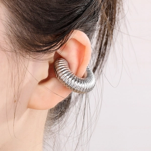 Macro side view of silver ribbed hollow C-shaped ear cuff on model ear