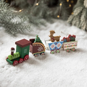 Festive painted wooden Christmas train with deer and gift boxes on snow background
