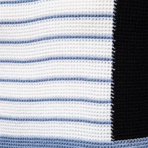Macro shot of striped knit sweater texture with white, blue, and black panels