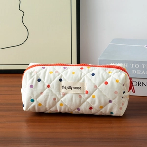 Detailed close-up of quilted cotton pencil case with colorful polka dots and red zipper