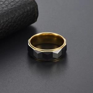 Bague pour homme en tungstène facetté bicolore gris et or sur un fond noir élégant