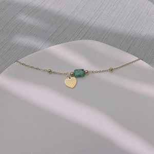 Dettaglio del ciondolo a cuore in oro 18 carati e perla turchese su collana vintage