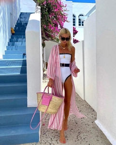 Close-up of pink striped resort cardigan paired with a belted white one-piece swimsuit