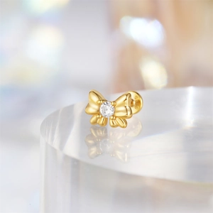 Detailed close-up of a 925 silver golden butterfly stud earring with clear gemstone