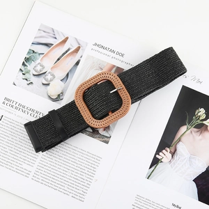 Detail of black woven straw belt with square wood buckle on a fashion magazine