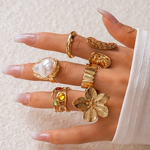 Detailed view of vintage gold ring set featuring baroque pearls and floral patterns