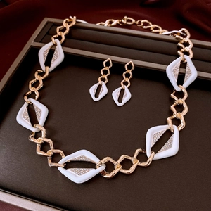Detail of luxury geometric jewelry set with white diamonds and gold chain on display