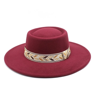 Detailed macro view of the burgundy wool felt hat with an ethnic geometric patterned band