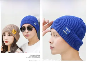 Close-up of knit beanies featuring MOMENT OF AMBITIONS square patch and warm textures