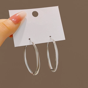 Close-up of a pair of large polished silver hoop earrings on a display card