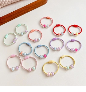 Dettaglio di elastici per capelli multicolori con perline per acconciature bimba