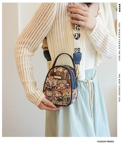Detail of cartoon bear jacquard fabric and navy leather trim on a mini crossbody bag