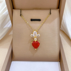 Detail of heart-shaped red gemstone necklace with white marquise zircons and gold chain