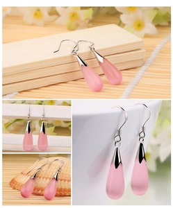 Close-up of pink cat eye stone teardrop earrings with silver hooks in various angles