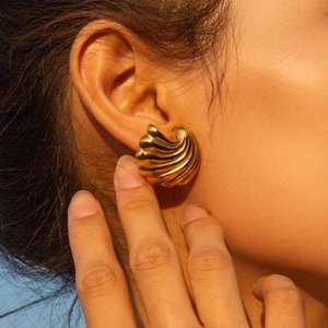 Close-up of golden shell earrings for women showing texture and metallic luster
