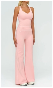 Vue de face d'un ensemble de yoga rose avec pantalon large et liseré blanc contrasté