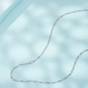 Collana a catena Figaro minimalista in argento sterling S925 su sfondo a onde blu