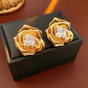 Gros plan détaillé de boucles d'oreilles fleur or 18k avec cristaux sur boîte bijoux