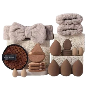 Brown makeup puff set with headband, wristbands, and beauty sponges on stone base