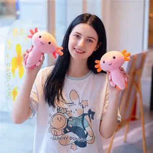 Pair of cute pink axolotl plush toys held by model in soft indoor lighting