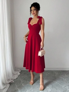 Detailweergave van een rode midi-jurk met elegante strikbandjes en een getailleerde taille