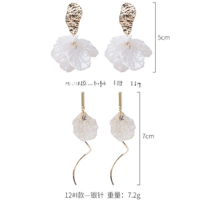 Vue détaillée de boucles d'oreilles fleurs en nacre blanche et métal texturé doré
