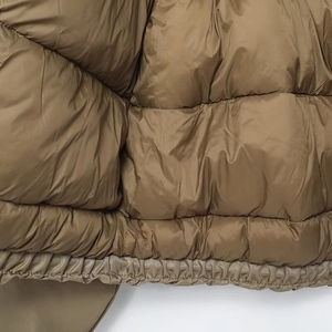 Detailed close-up of brown quilted nylon fabric texture and stitching for bomber jacket