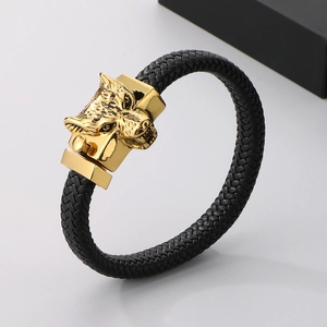 Close-up of golden wolf head clasp and black braided leather strap on punk bracelet
