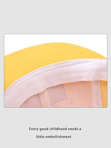 Detailed macro view of yellow cotton fabric and fine stitching on a kids baseball cap