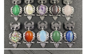 Detailed macro view of owl jewelry collection with diverse inlaid natural crystal gemstones