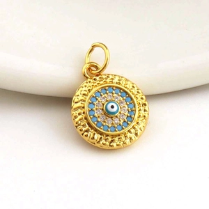 Macro shot of gold evil eye pendant with blue and white zircon micro-inlay details