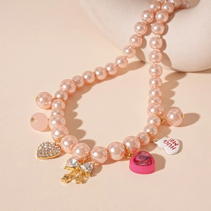 Collier ras de cou en perles roses avec pendentifs cœur strass et nœud papillon