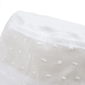 Gros plan du tissu blanc à pois suisses et des coutures précises sur le chapeau