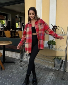 Detailed texture of red and beige wool plaid shirt on a female model outdoors