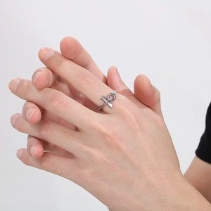 Macro shot of silver stainless steel Ankh cross ring worn by a model on plain background