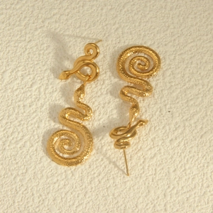 Vintage gold snake spiral earrings with hammered texture on a neutral stone background