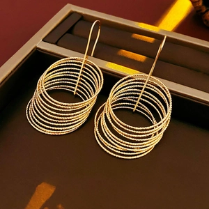 Macro shot of multi-layer golden hoop earrings placed in a premium dark display box