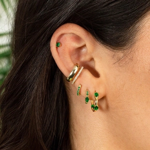 S925 silver needle gold hoop earrings with green zircon gems worn on model's ear