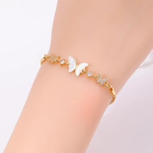 Detail of a gold-plated bracelet with white iridescent butterfly and crystal accents